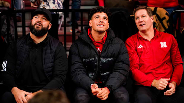 Nebraska quarterback commit Dylan Raiola (center) sits with his uncle, offensive line coach Donovan Raiola and athletic director Trev Alberts at a Huskers basketball game.